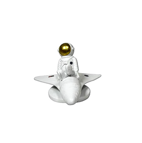 Small figurine of an astronaut on a rocket with a gold helmet against a transparent background