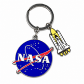 NASA-themed keychain with a circular blue NASA emblem charm and a white space shuttle charm on a silver split ring, shown on a plain white background.